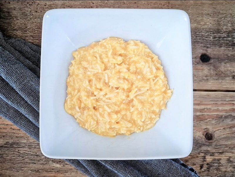 En skål med risgrynsgröt som har en krämig konsistens och ljusgul färg.